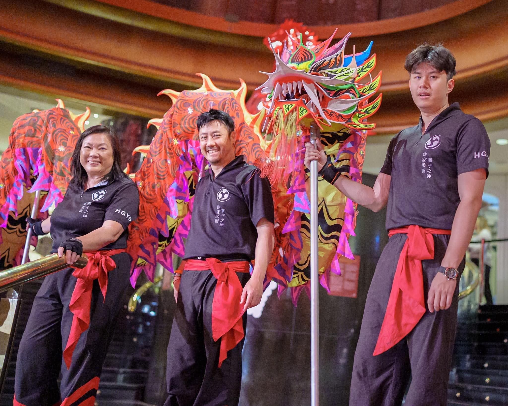 Three people in front of dragon before Lunar New Year performance